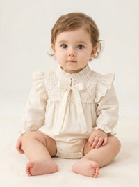 Thumbnail for Baby's vintage antique white long sleeved romper set with lace accents on a beige background.