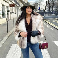 Thumbnail for Woman in white striped faux fur coat and hat standing on a city street