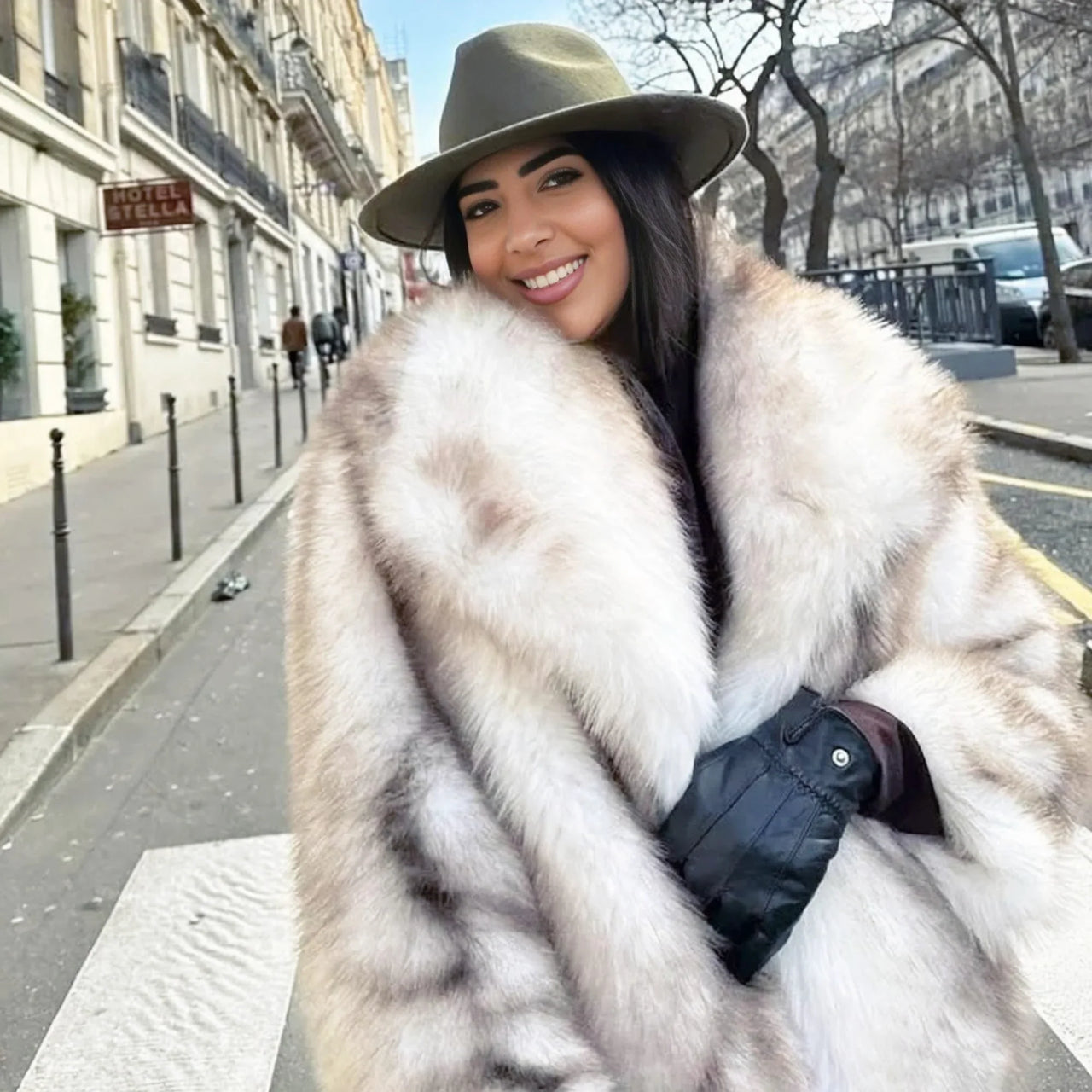 Woman wearing a white striped faux fur coat and hat on a city street