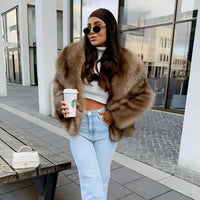 Thumbnail for Woman in a brown faux fur coat holding a Starbucks cup outdoors