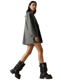 Thumbnail for Woman wearing a gray coat and brown chucky boots on a white background