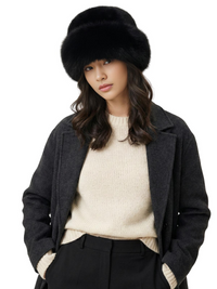 Thumbnail for Woman wearing a black faux fur hat, dark coat, and beige sweater on a white background