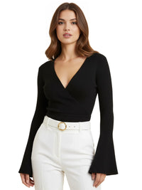 Thumbnail for Woman wearing a black ribbed sweater with bell sleeves and white pants on a white background