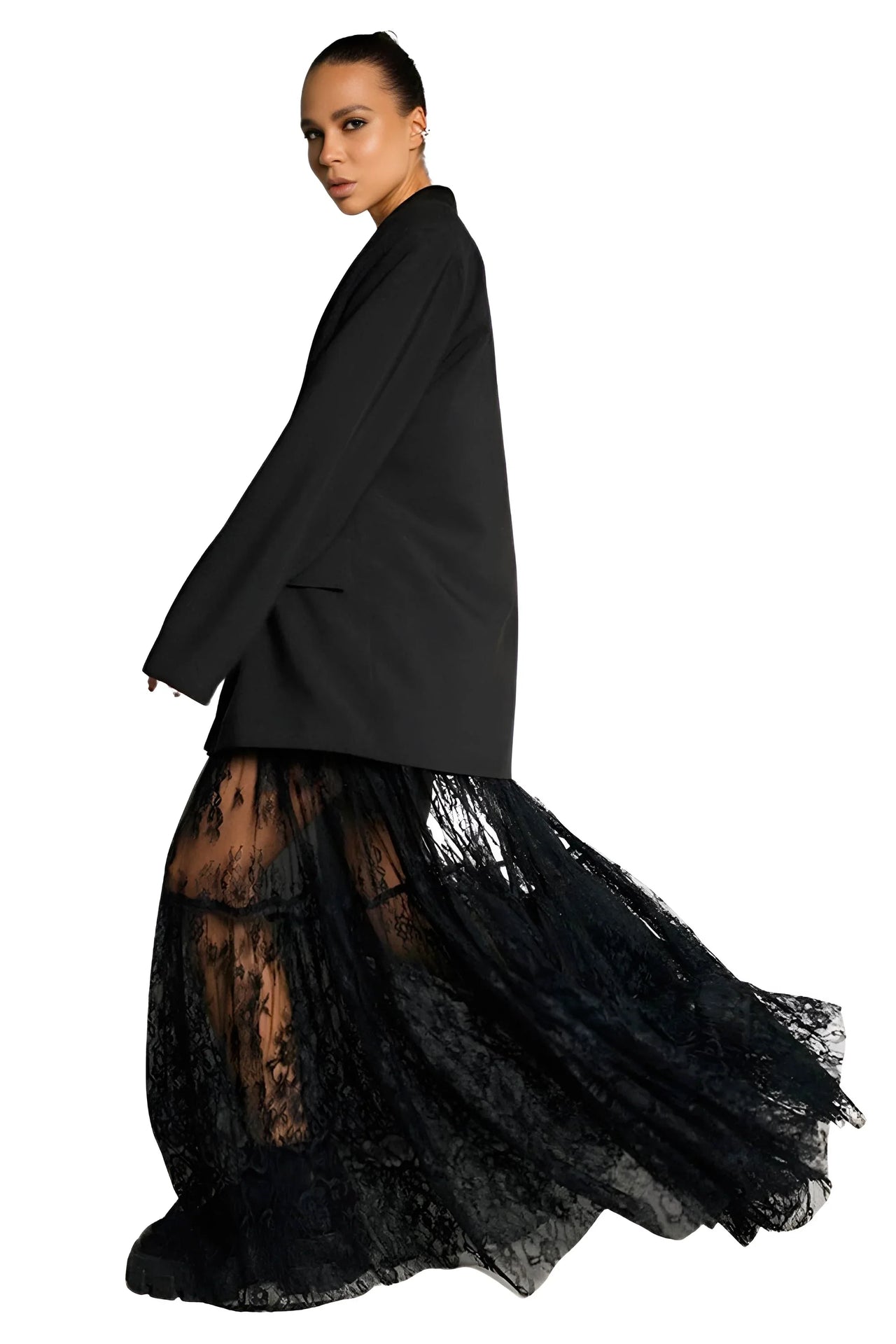 Person wearing a black coat over a black lace skirton a white background
