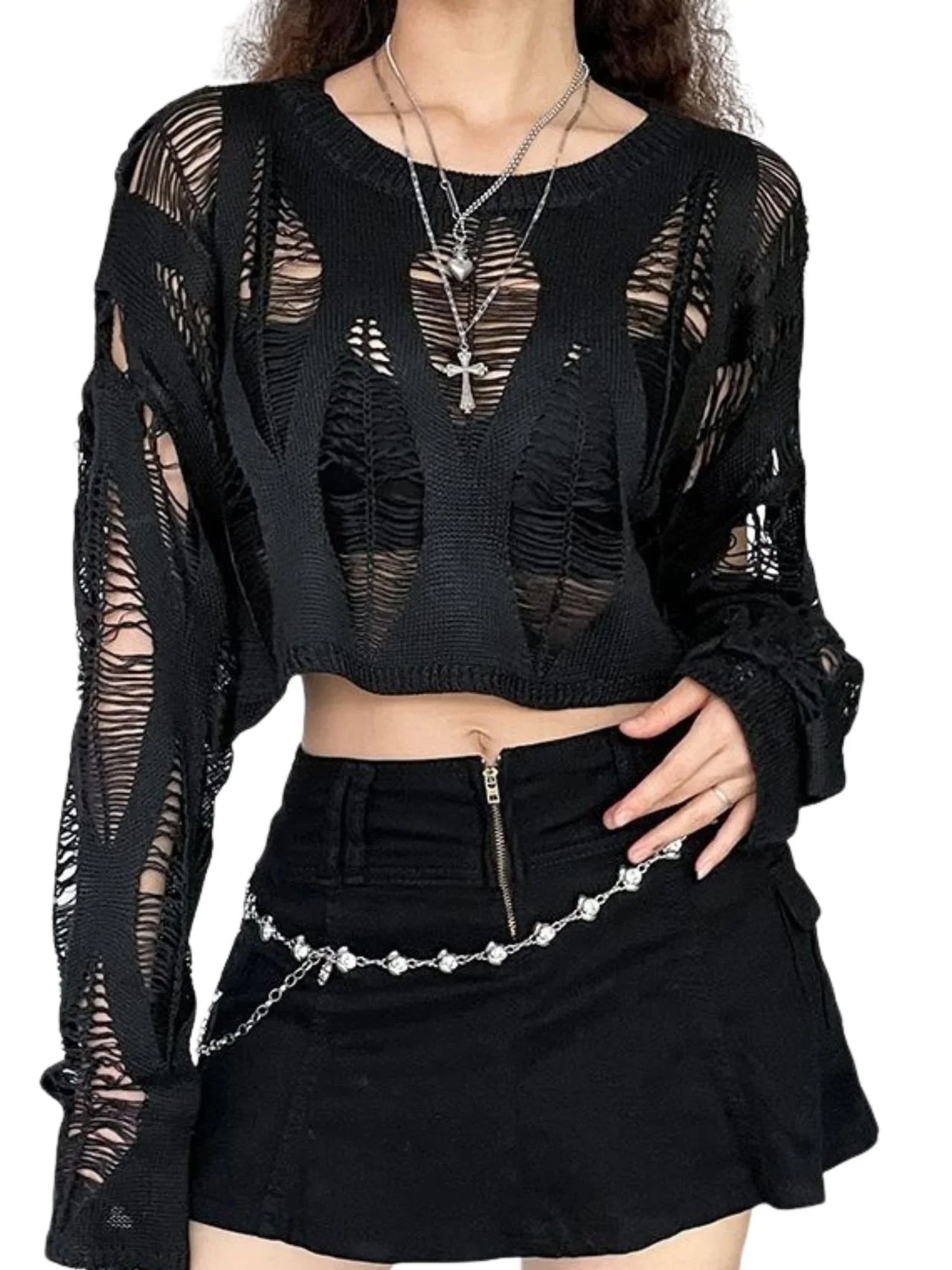 Black sheer long-sleeve top and black skirt worn by a person on a white background