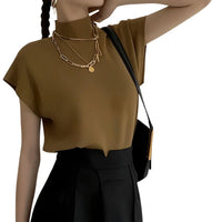 Thumbnail for Woman wearing a brown short sleeve sweater and black pants with a gold necklace on a white background