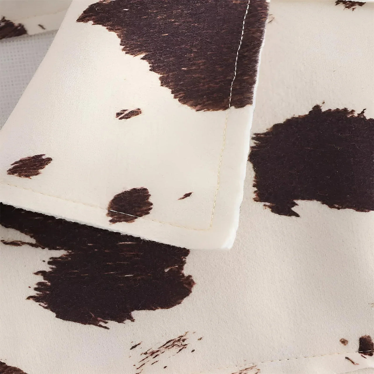 Close-up of a cow print fabric with brown and white pattern
