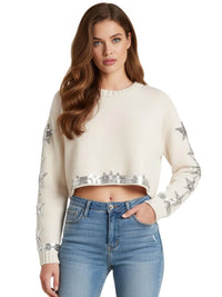 Thumbnail for Model wearing Drestiny Women's Cropped Sequin Sweater in white with silver sequin star detailing on sleeves and hem, styled with high-rise jeans for chic modern sparkle.