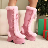 Thumbnail for Pink platform boots with fluffy trim worn by a person, with Christmas presents and a tree in the background.