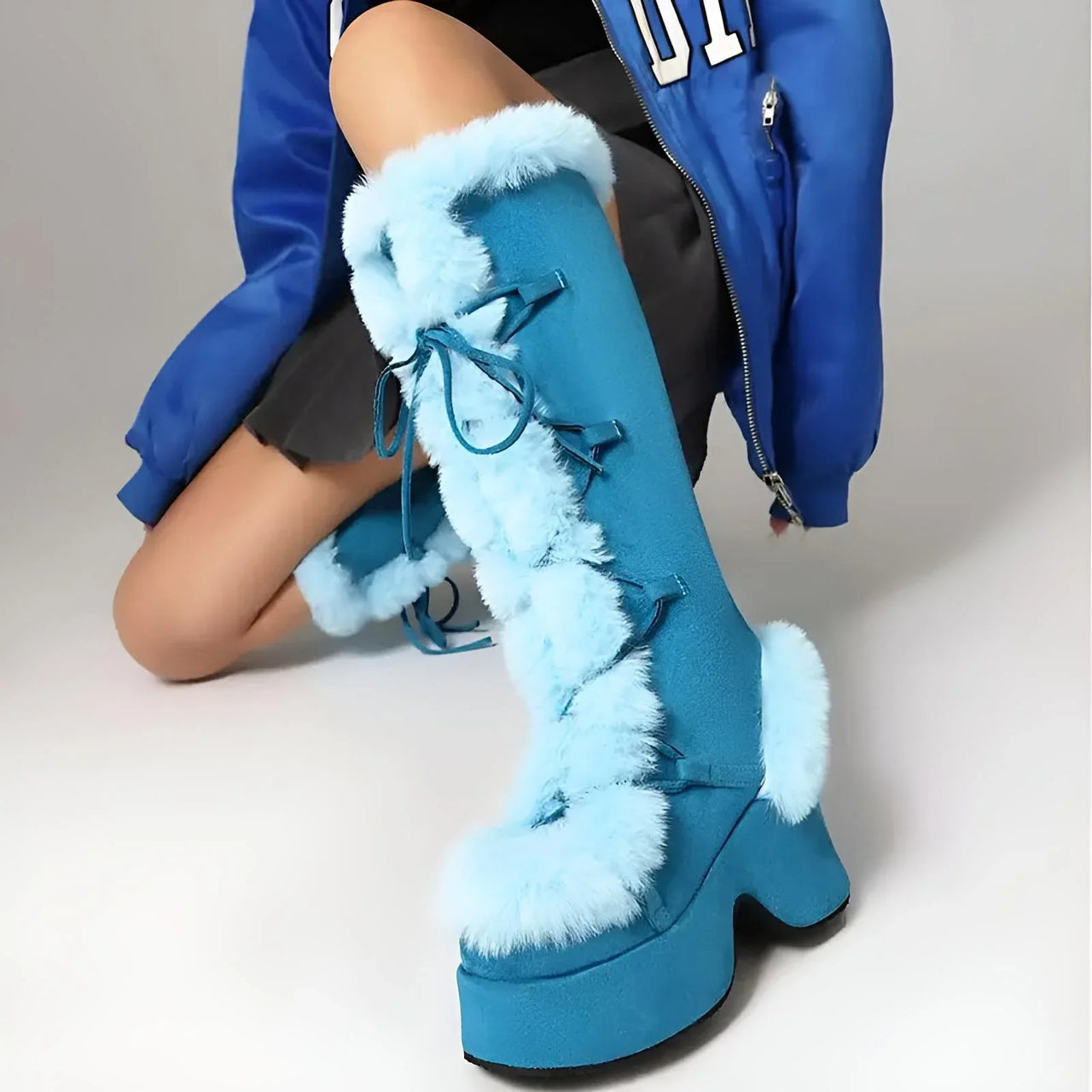 Blue platform boots with fur trim worn by a person in a blue jacket.