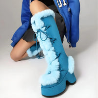 Thumbnail for Blue platform boots with fur trim worn by a person in a blue jacket.