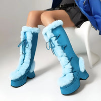 Thumbnail for Blue furry boots worn by a person sitting on a white chair.