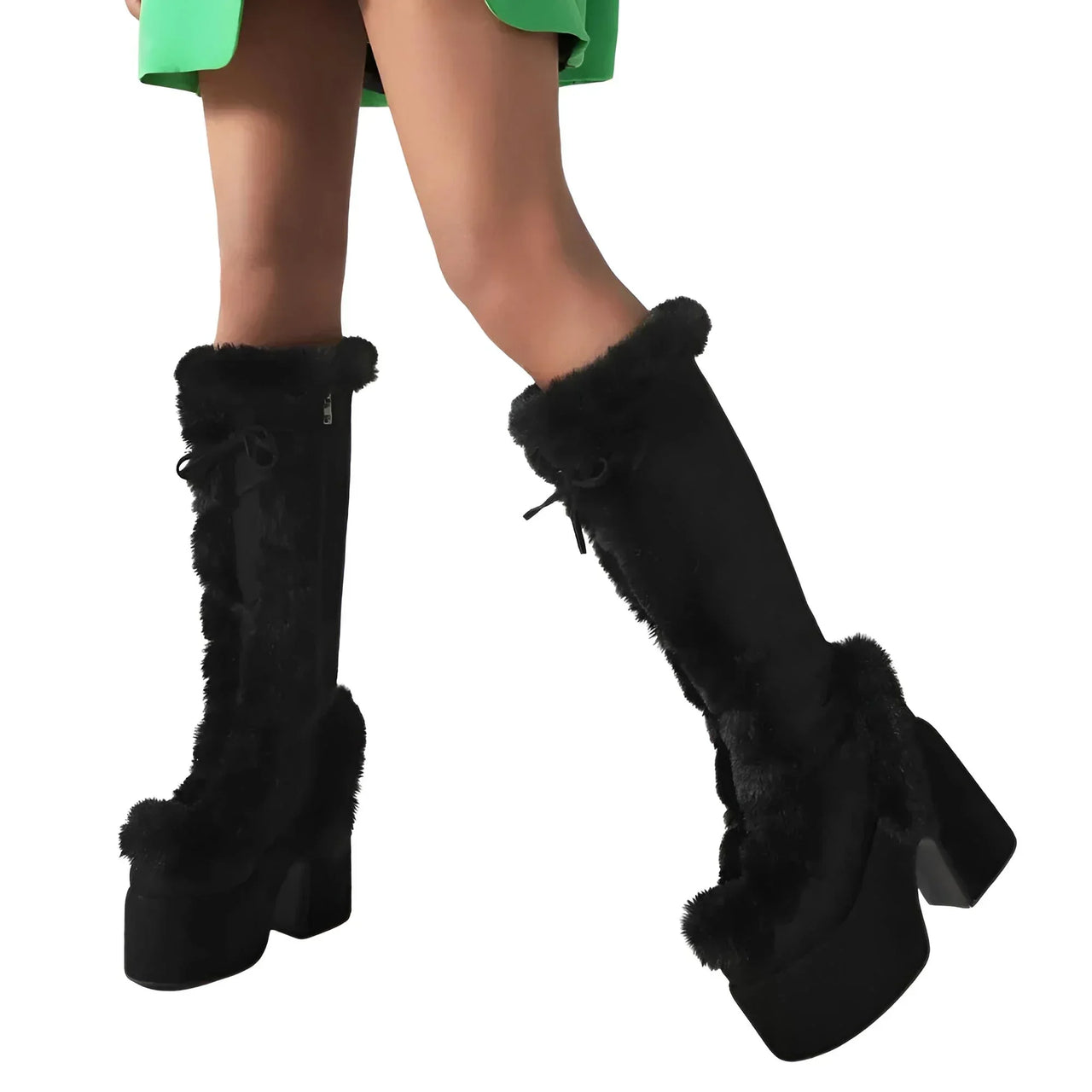 Black knee-high boots with fur trim worn by a person on a white background
