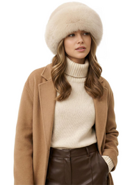 Thumbnail for Woman wearing a beige faux fur hat, brown coat, white turtleneck sweater, and brown leather pants on a white background
