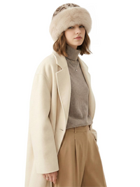 Thumbnail for Woman wearing a cream coat, brown sweater, beige pants, and a beige leopard print faux fur hat on a white background