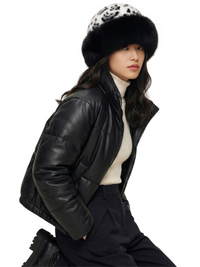 Thumbnail for Person wearing a black leather jacket, white sweater, and dark pants with a white-black leopard print faux fur hat on a white background