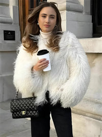 Thumbnail for Woman in a white faux fur coat holding a coffee cup and a Chanel handbag.
