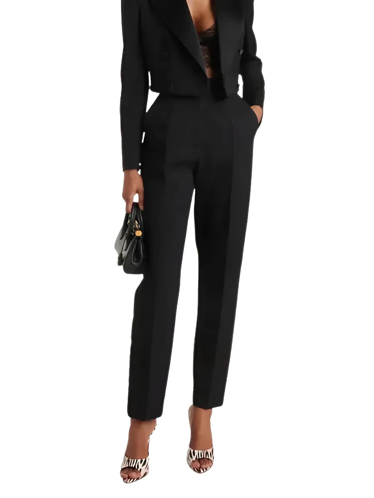 Person wearing a black suit holding a black handbag wearin leopard print peep toe heels on a white background
