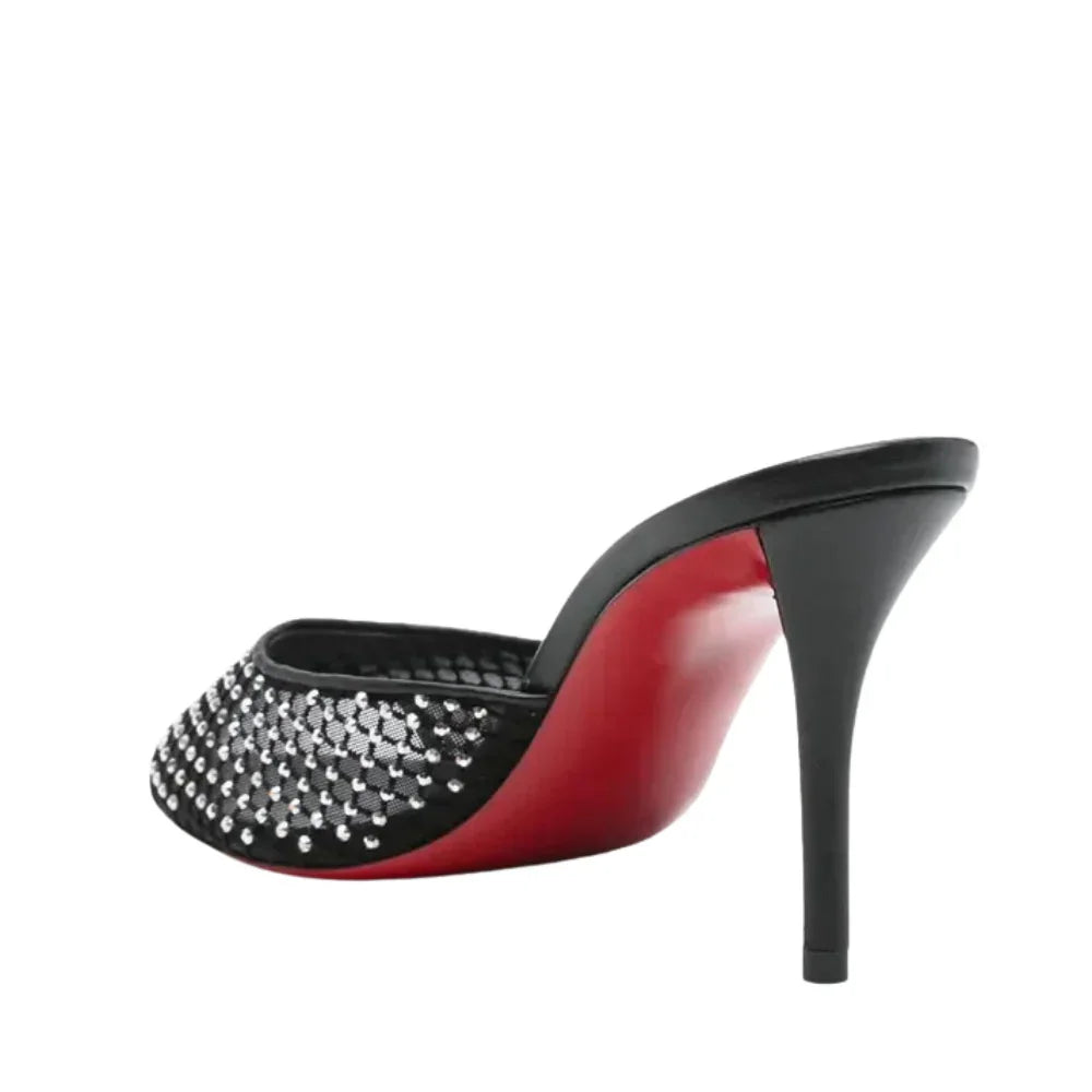 High-heeled red sole shoe with diamond studded detail on a white background