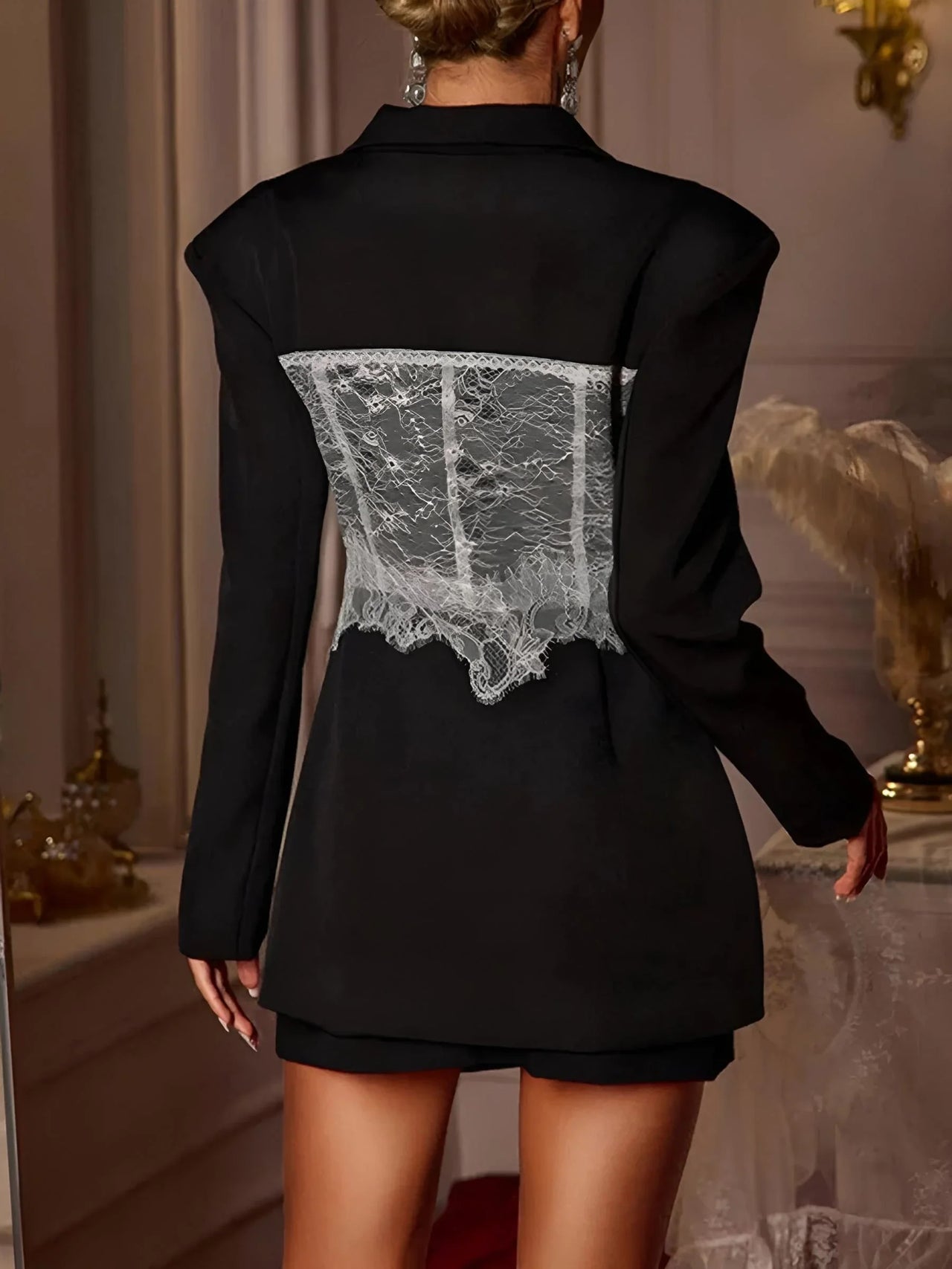 Black blazer with lace detailing on the back in an elegant indoor setting