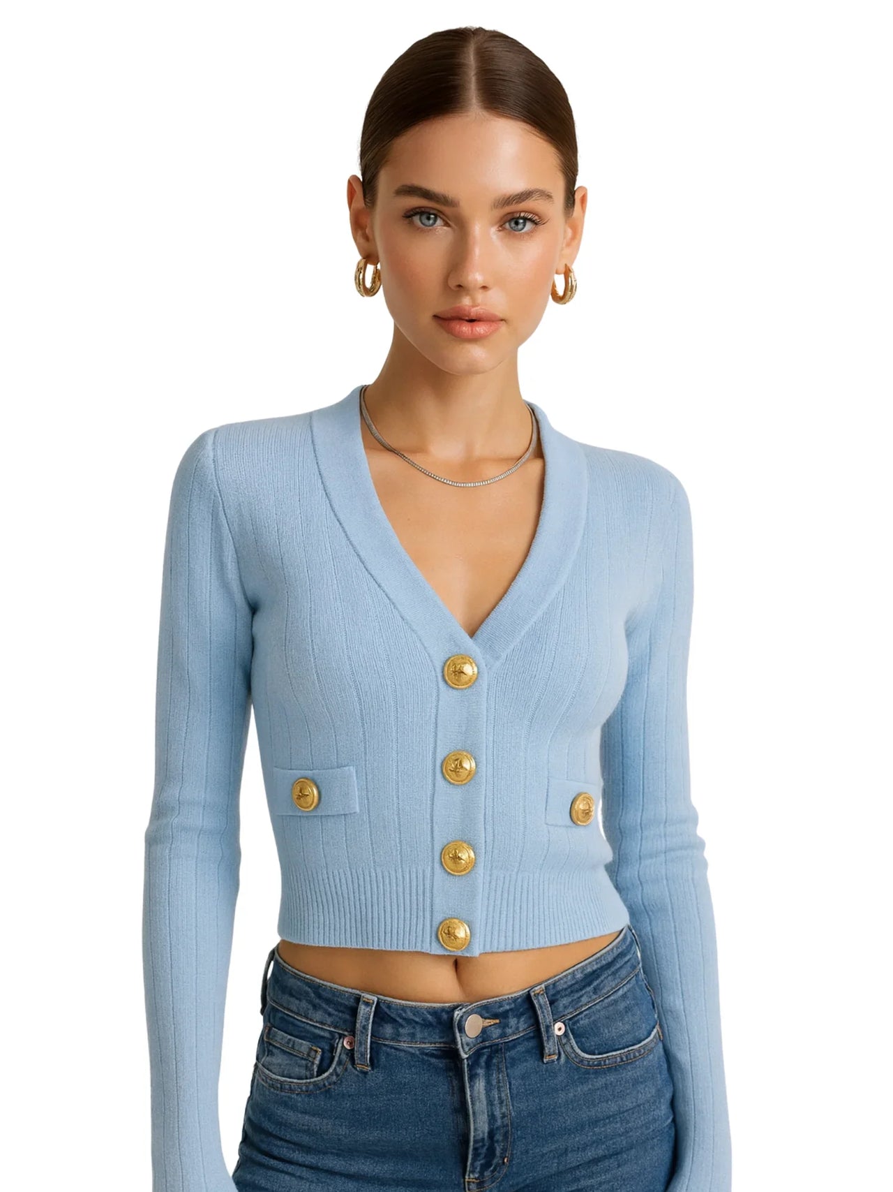 Woman wearing a light blue cardigan with gold buttons on a white background