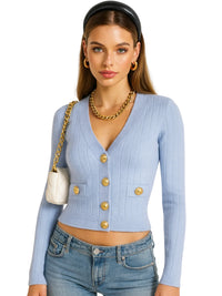 Thumbnail for Woman wearing a light blue cardigan with gold buttons, holding a white handbag.