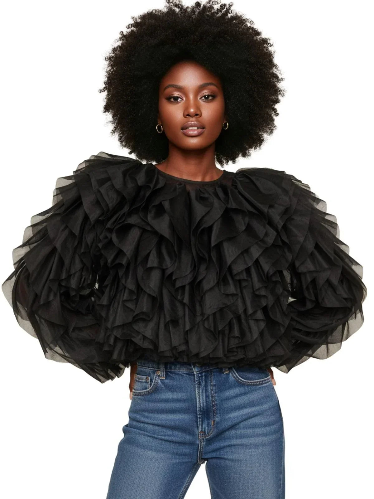 Woman wearing a black ruffled blouse and blue jeans on a white background