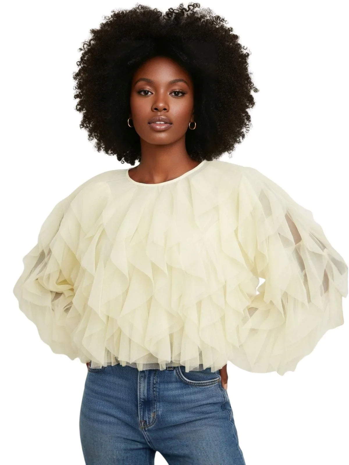 Woman wearing a light-colored blouse with puffed sleeves and blue jeans on a white background