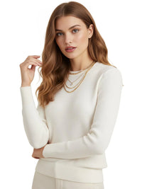 Thumbnail for Woman wearing a white sweater with layered gold necklaces on a white background