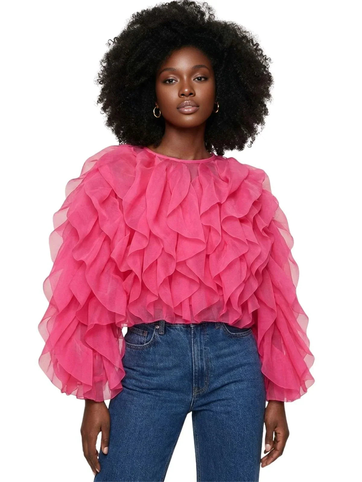 Woman wearing a pink ruffled blouse and blue jeans on a white background