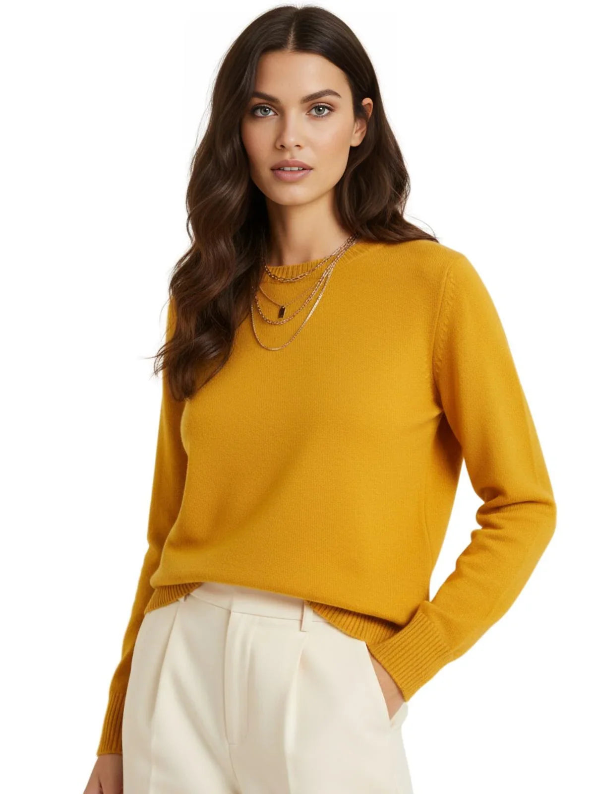 Woman wearing a ginger yellow sweater and white pants on a white background