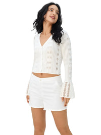 Thumbnail for Woman wearing a white sweater and shorts with decorative elements on a white background