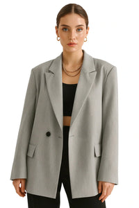 Thumbnail for Woman wearing a gray blazer over a black top on a white background