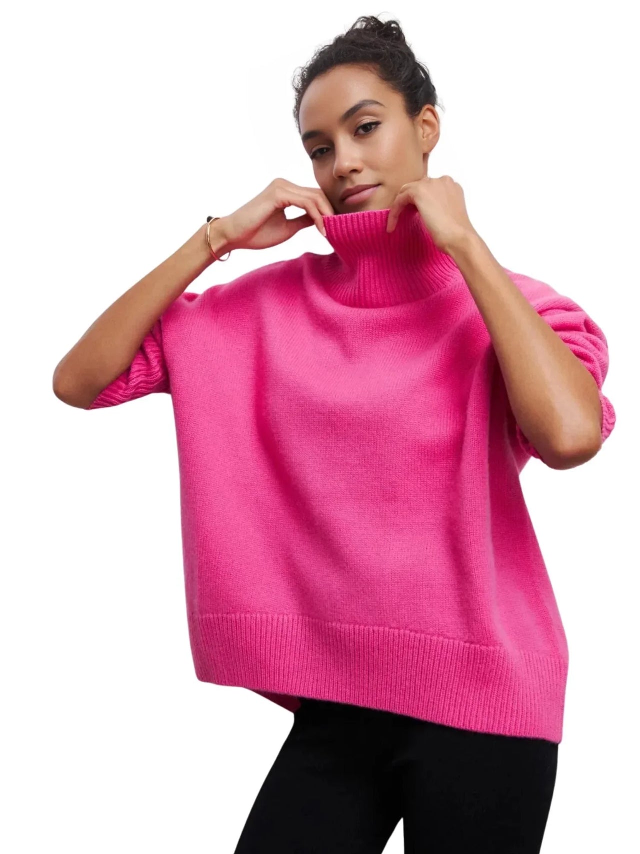 Woman wearing a bright pink sweater on a white background