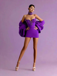 Thumbnail for Woman wearing a purple mini dress with large sleeves against a matching background
