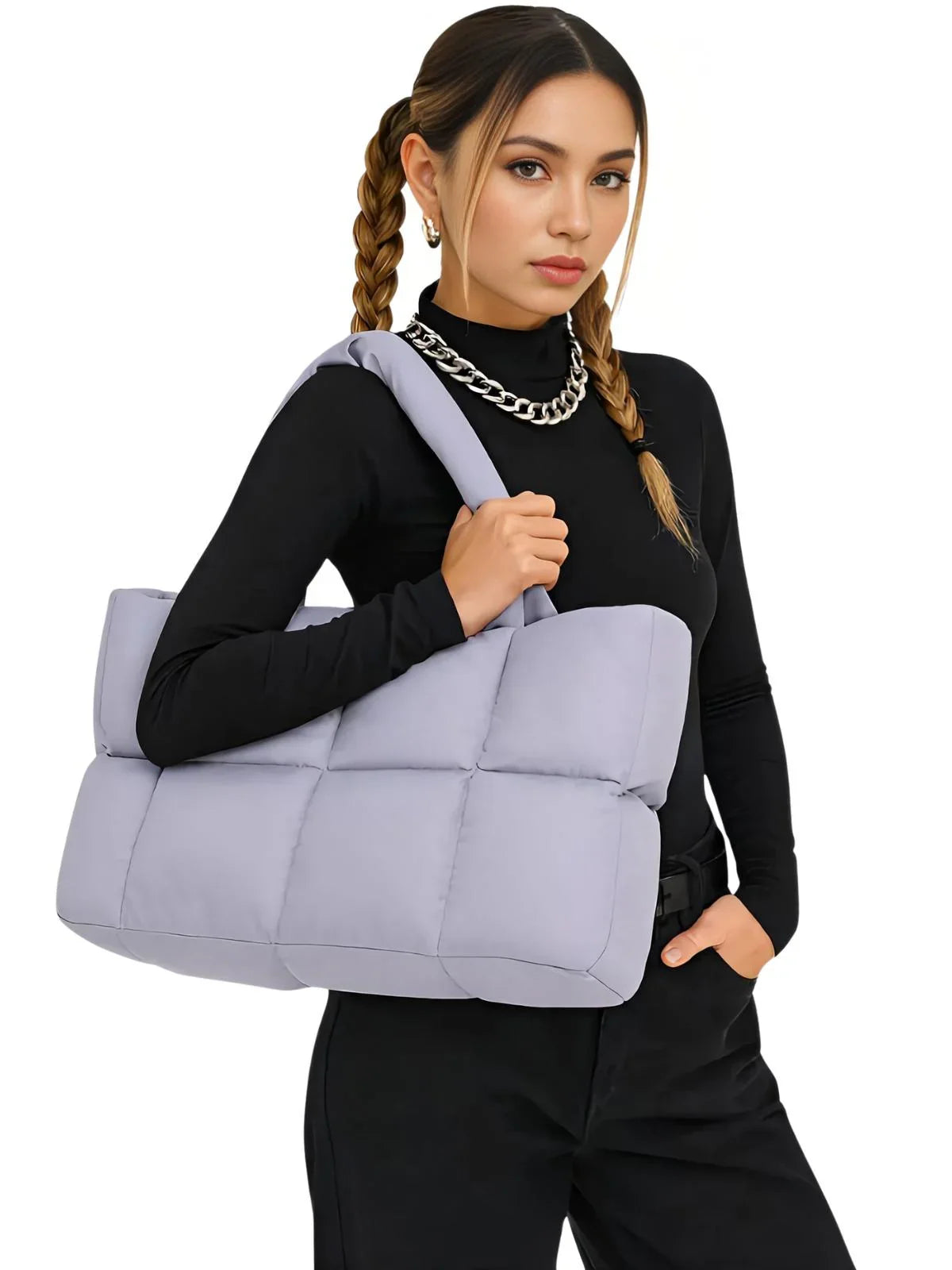 Woman carrying a purple puffer bag against a white background