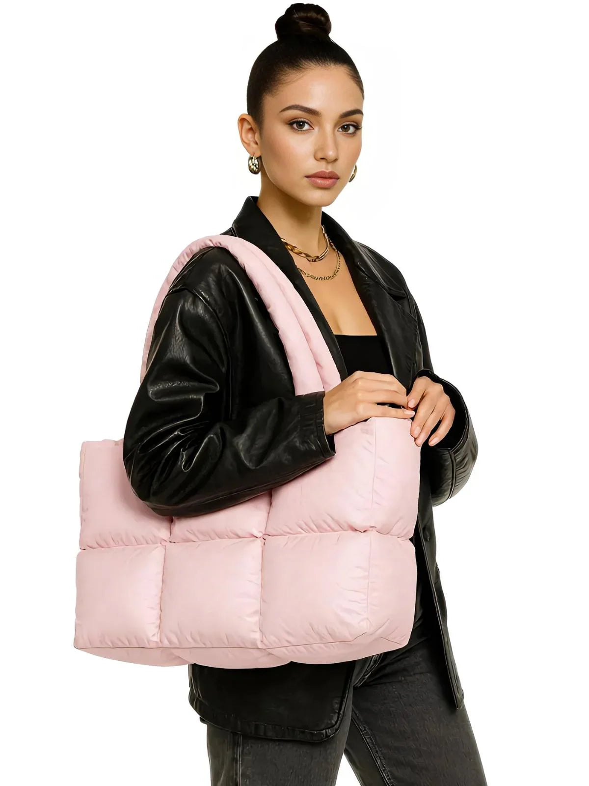 Woman holding a pink puffer bag against a white background