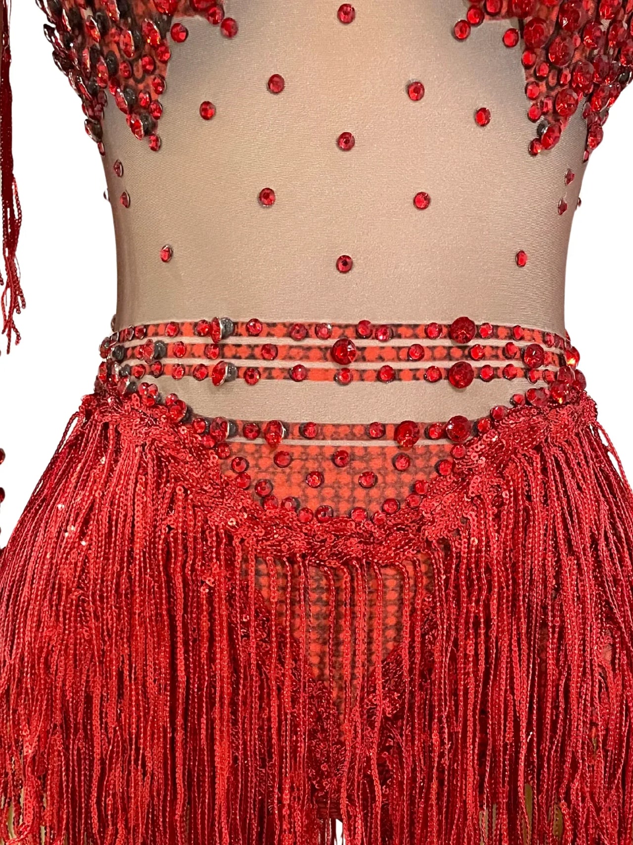 Red beaded and fringed top and skirt set on a plain background