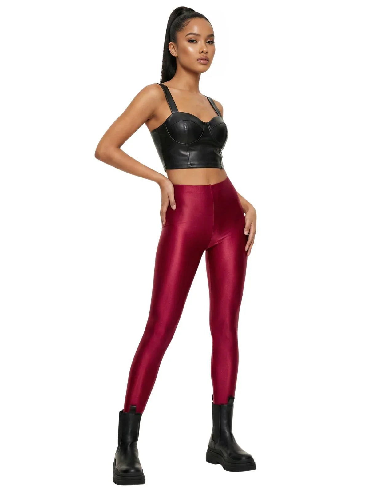 Woman wearing red leggings and black leather top on a white background
