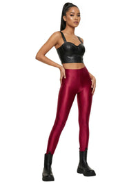 Thumbnail for Woman wearing red leggings and black leather top on a white background