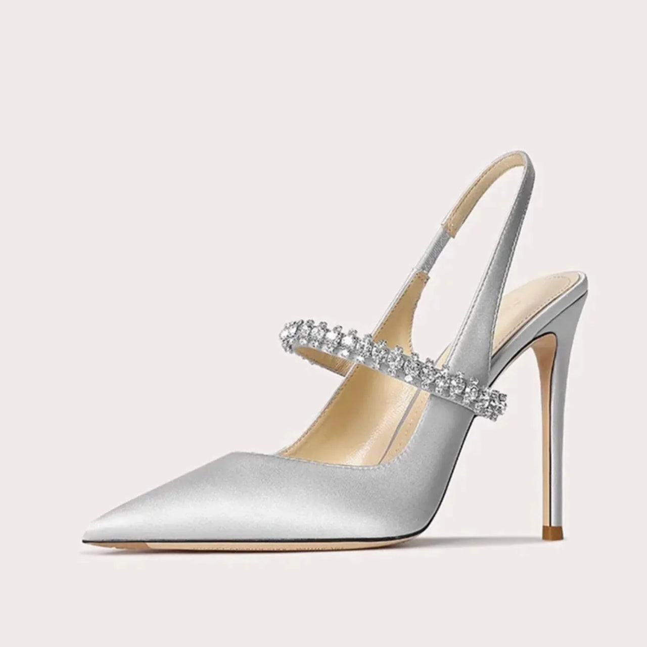 Silver high-heeled shoe with a decorative crystal strap on a light gray background