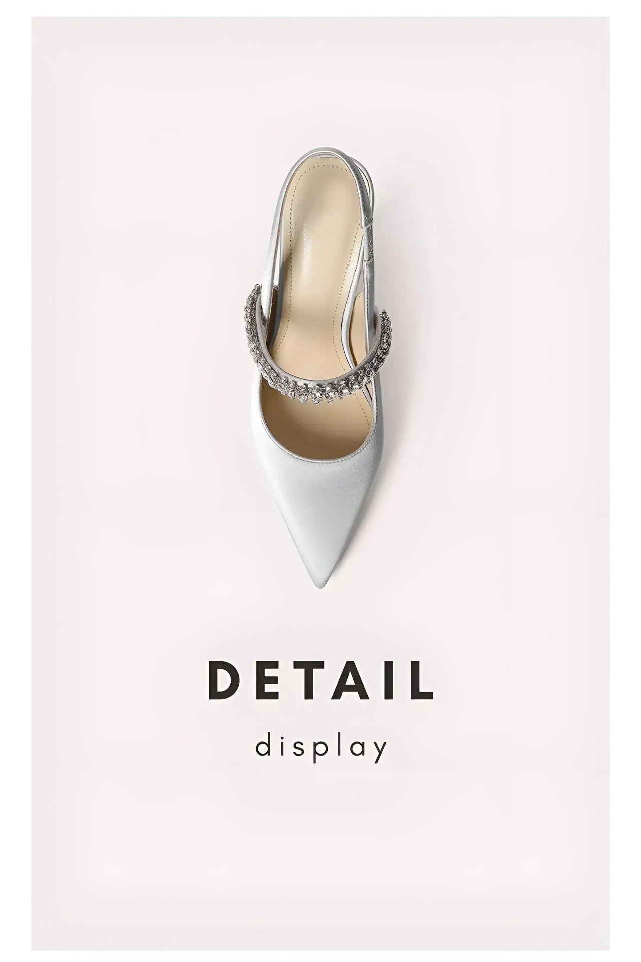 Gray high-heeled shoe with a decorative strap on a light pink background