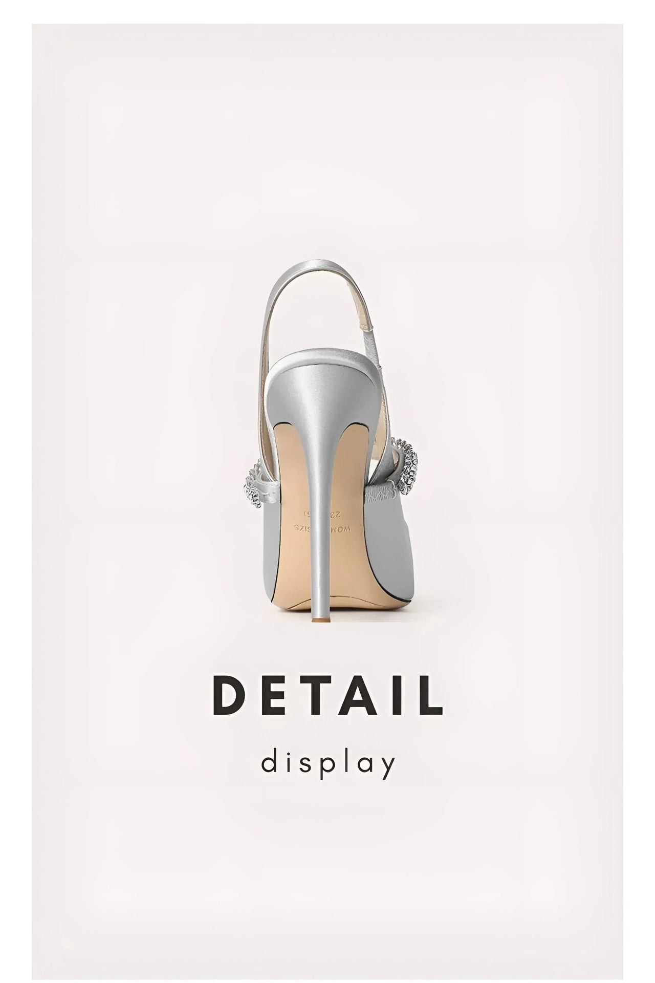 Silver high-heeled shoe with decorative elements on a light gray background