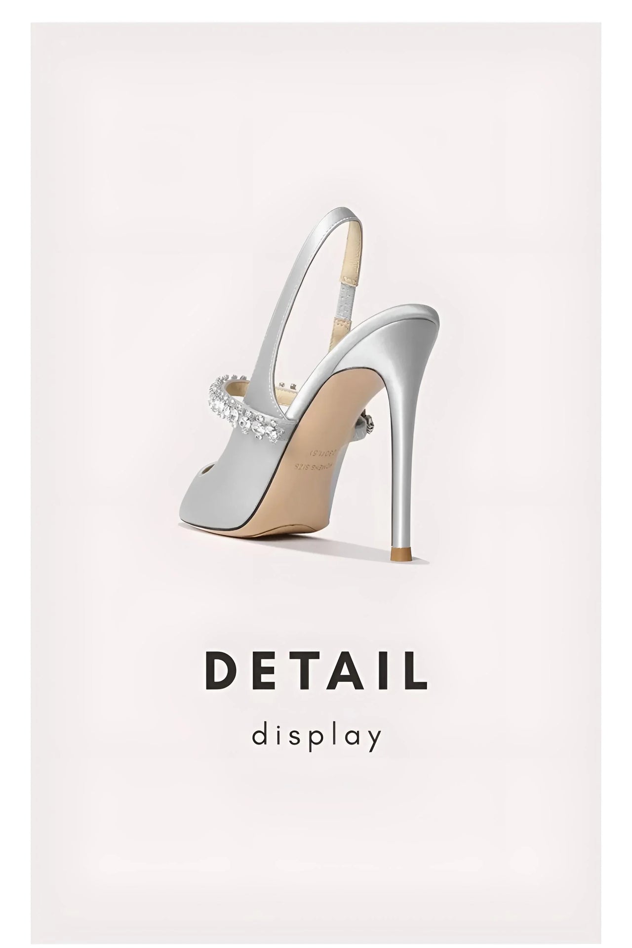 Silver high-heeled shoe with a detailed sole on a light gray background