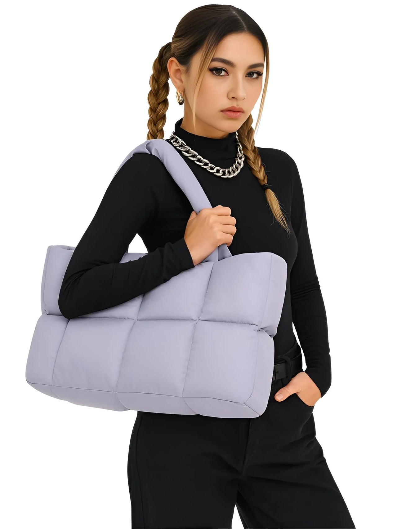 Woman holding a light purple puffer bag against a white background