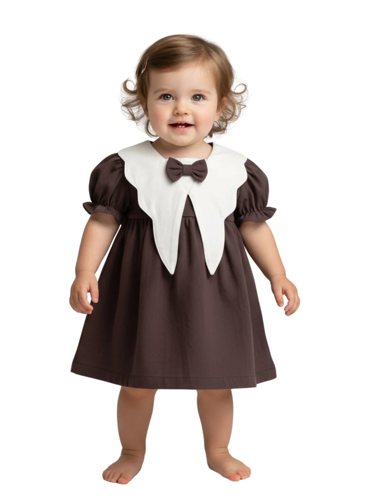 Child wearing a brown dress with a white collar and bow tie on a white background