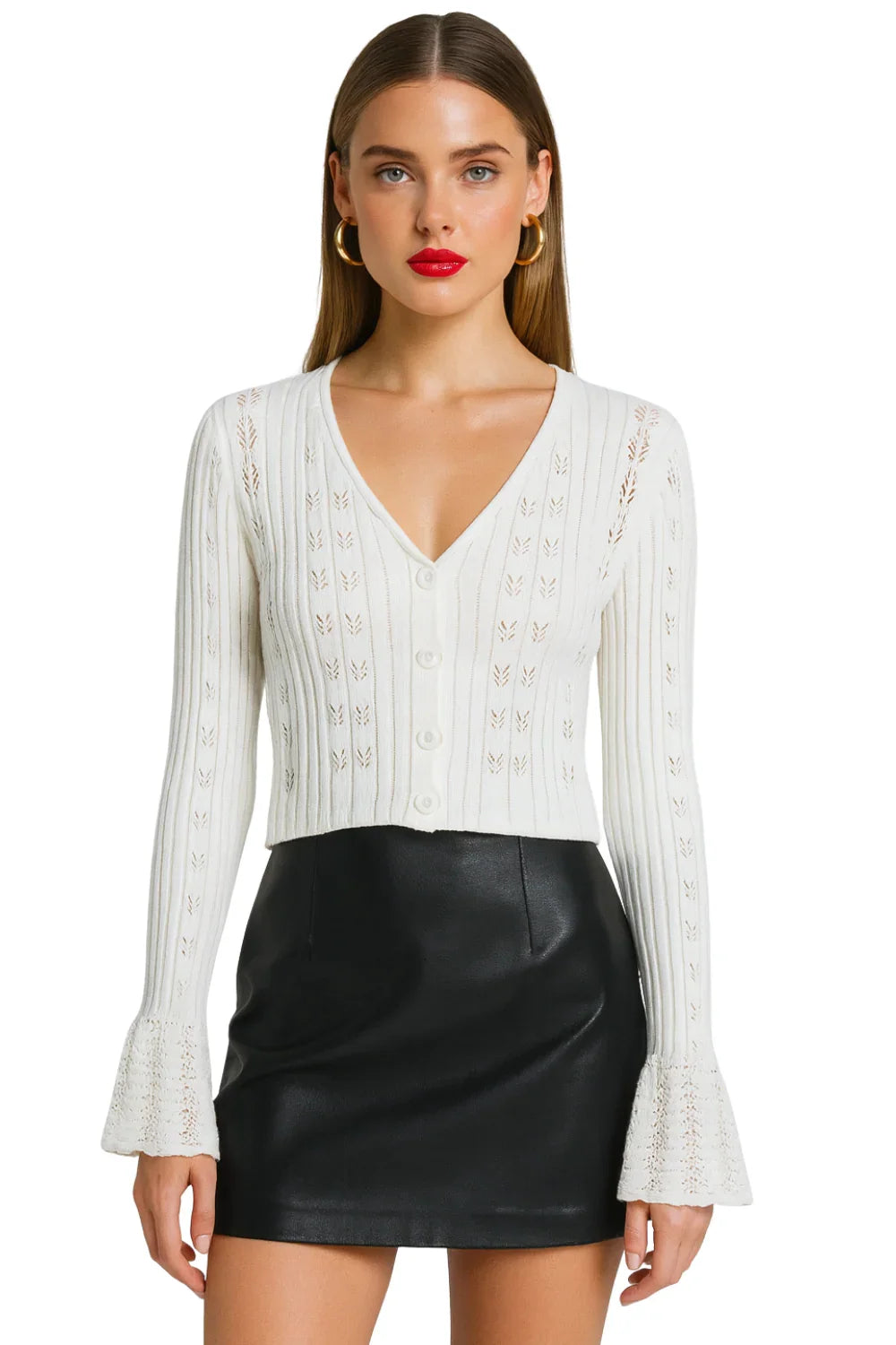 Woman wearing a white cropped long-sleeve cardigan and black leather skirt on a white background