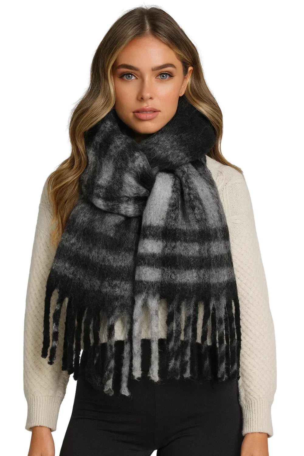 Woman wearing a black and gray plaid scarf with fringe on a white background