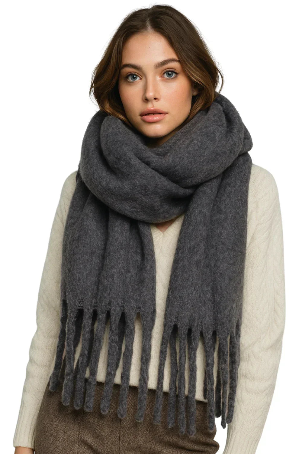 Woman wearing a dark gray scarf with fringes on a white background