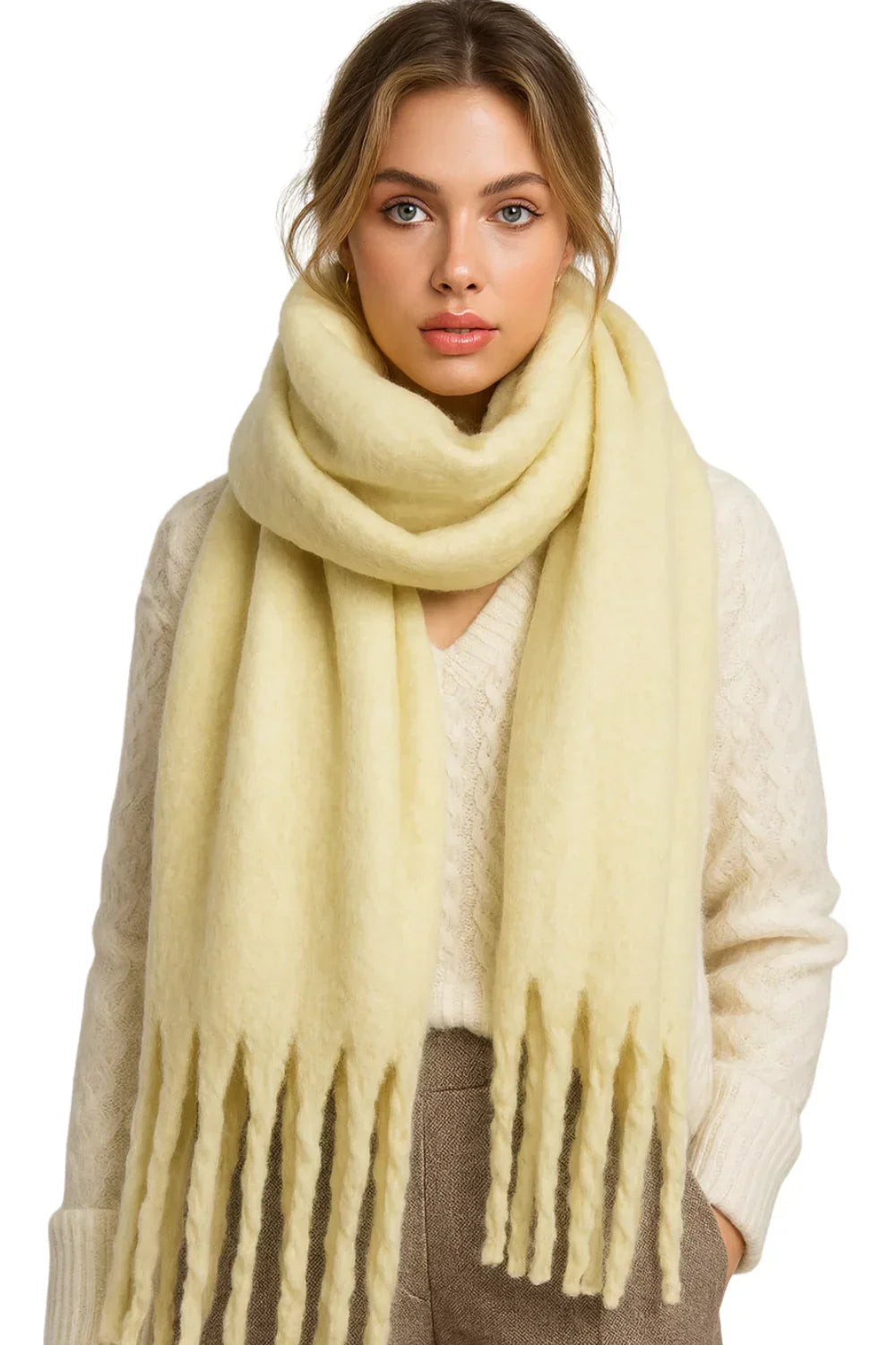 Woman wearing a light yellow scarf with fringes on a white background